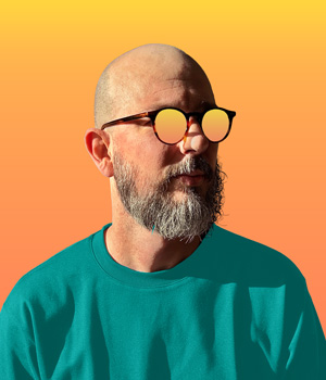 Victor on a sunny day, wearing reflective sunglasses.
