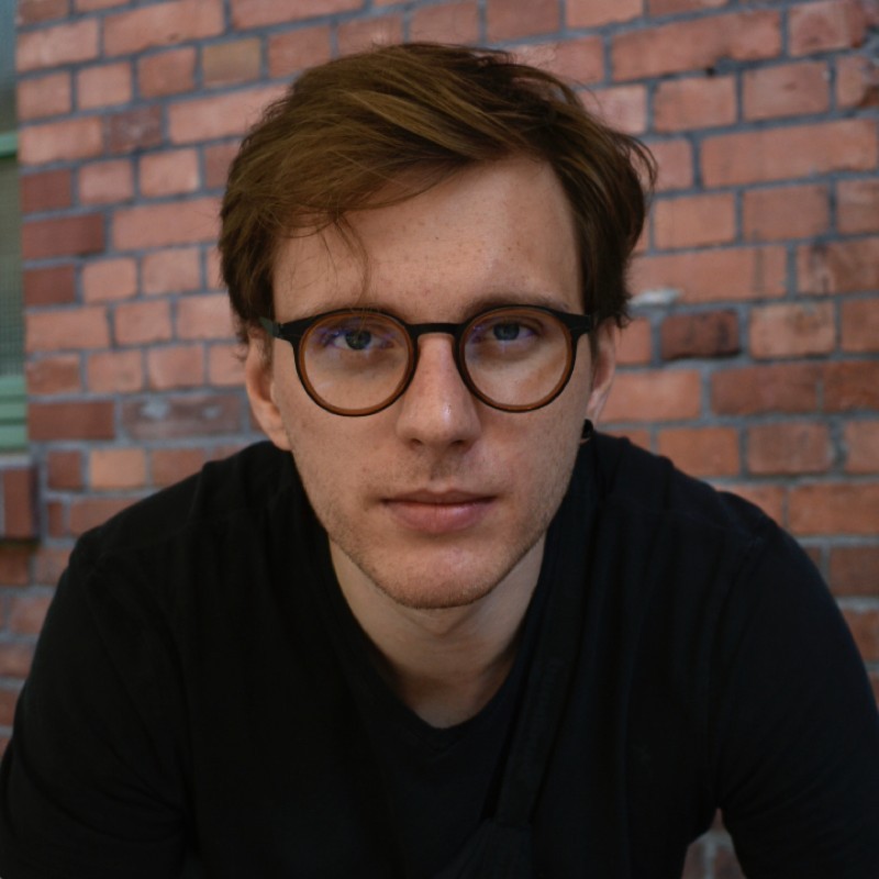Portrait of Damian, white man wearing glasses, Staff Product Designer.